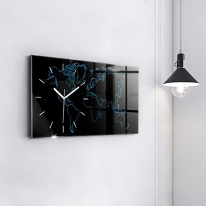 Puede incluir: Un reloj negro con un diseño de mapa del mundo y agujas blancas. El reloj está hecho de vidrio y tiene una superficie reflectante.