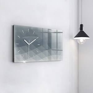 May include: A modern gray and white clock with a geometric design. The clock is mounted on a white wall.