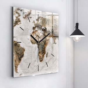 May include: A square glass clock with a world map design. The map is in shades of brown and beige on a white background. The clock hands are black.