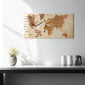May include: A rectangular wall clock with a world map design. The clock face is beige with brown continents and black clock hands. The numbers 1 through 12 are printed in black around the clock face.
