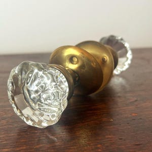 Ensemble de poignées de porte anciennes en verre transparent avec rosaces en laiton et axe d'origine de 1/4".