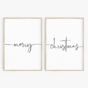 Puede incluir: Dos impresiones enmarcadas con las palabras "merry" y "christmas" escritas en cursiva. Las impresiones son sobre fondo blanco y tienen un marco de madera claro.