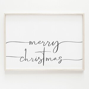 May include: A framed rectangular sign with the words "merry christmas" in elegant black script on a white background. The sign has a light-colored wooden frame, suitable for holiday decor.