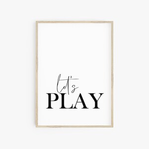 May include: A black and white printable wall art print with the text "Let's Play" in a modern font.