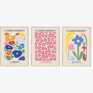 May include: Three colorful posters with the text "Flower Market" at the top. The posters feature abstract floral designs in pink, blue, yellow, green, and orange. The posters are labeled "Lisbon", "London", and "Madrid".