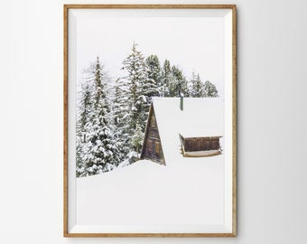 Könnte beinhalten: Ein gerahmtes Foto einer Holzhütte mit einem schneebedeckten Dach, eingebettet in schneebedeckte Nadelbäume. Die Hütte ist von einer weißen Schneedecke umgeben.