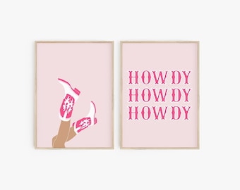 Pode incluir: Duas impressões emolduradas cor-de-rosa com fundo cor-de-rosa. A impressão à esquerda mostra um par de botas de cowboy brancas com detalhes em rosa. A impressão à direita tem o texto "HOWDY HOWDY HOWDY" em rosa.