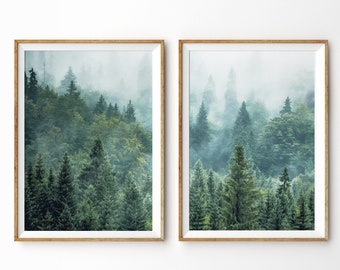 May include: Two framed prints of a misty forest scene with tall evergreen trees. The prints are in a light wood frame and are hung on a white wall.