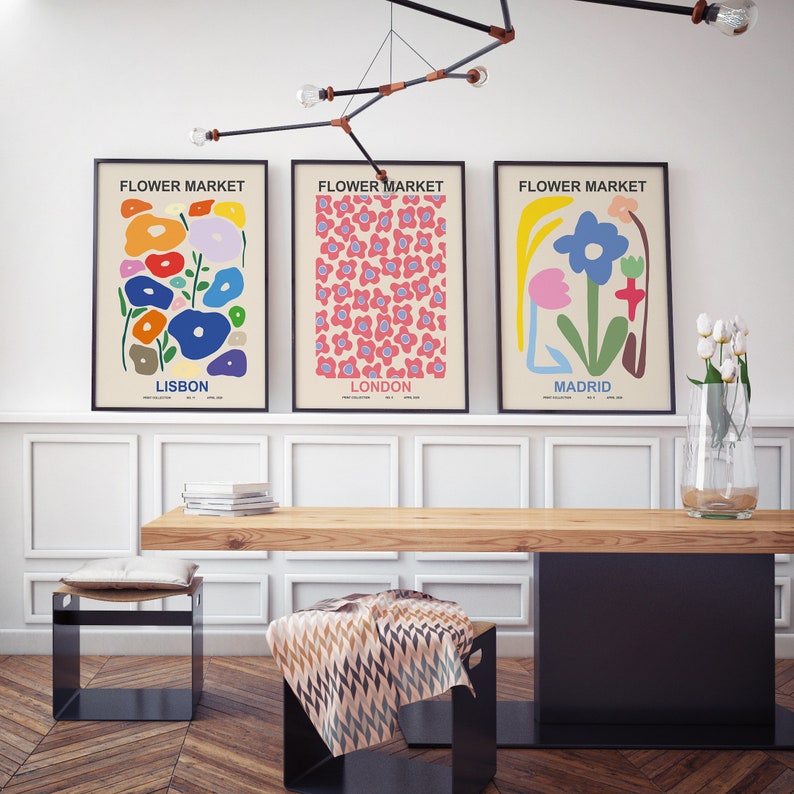 May include: Three colorful posters with the text "Flower Market" and the names of cities: Lisbon, London, and Madrid. Each poster features a different abstract floral design.