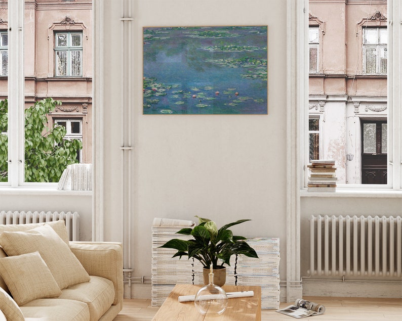 May include: A framed print of a painting depicting a pond with water lilies and a blue sky. The painting is in a light wood frame and is hanging on a white wall.