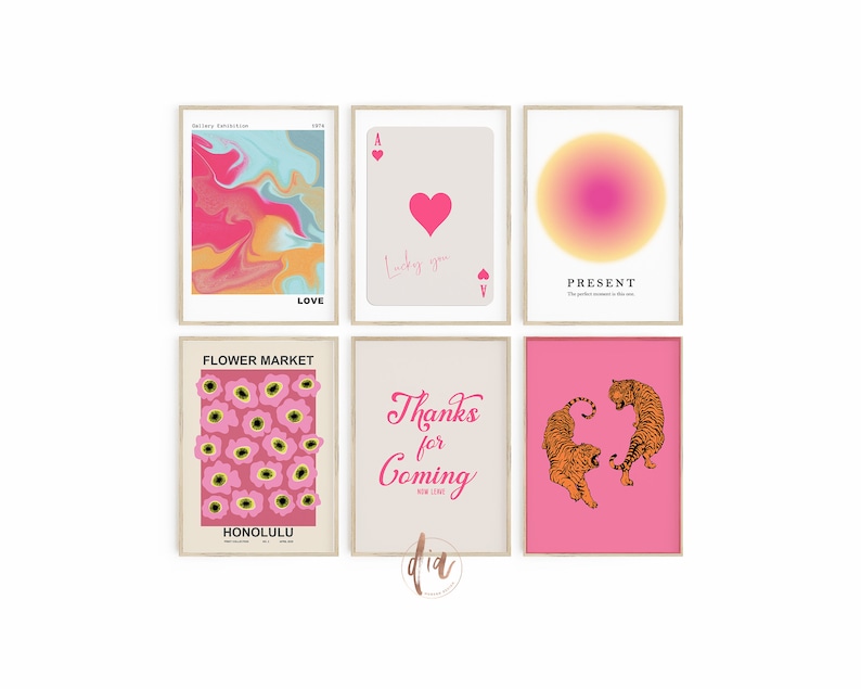 May include: Six pink and white framed prints with various designs. The prints include a pink and blue abstract design, a playing card with a heart, a gradient circle, a pink floral pattern, a pink background with the text "Thanks for Coming", and two orange tigers on a pink background.