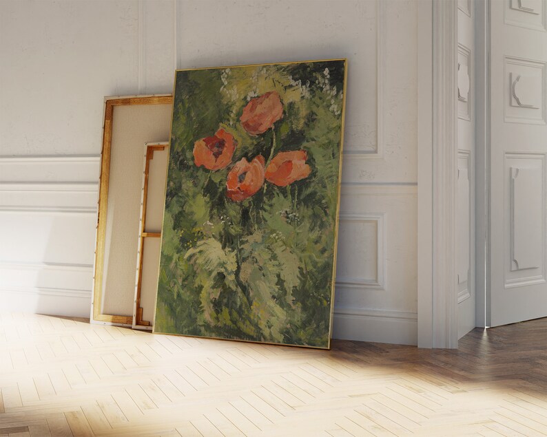 Puede incluir: Una pintura al &oacute;leo de flores naranjas sobre un fondo verde, enmarcada en oro. Otros dos lienzos se apoyan en la pared. La pintura se exhibe en una habitaci&oacute;n con paredes blancas y suelo de madera.