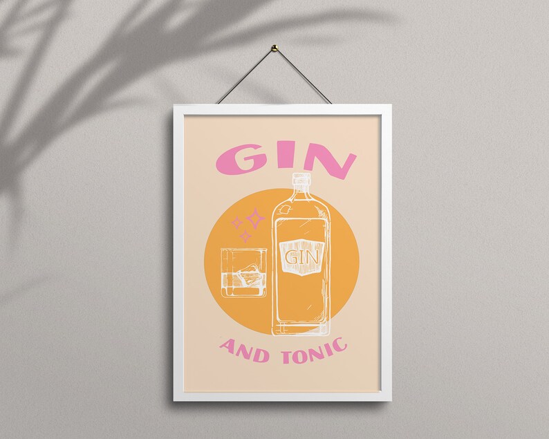 May include: A white framed poster with a peach background and a yellow circle. The circle contains a line drawing of a bottle of gin and a glass of gin with ice. The text "GIN AND TONIC" is in white letters below the circle. The word "GIN" is in pink letters above the circle.
