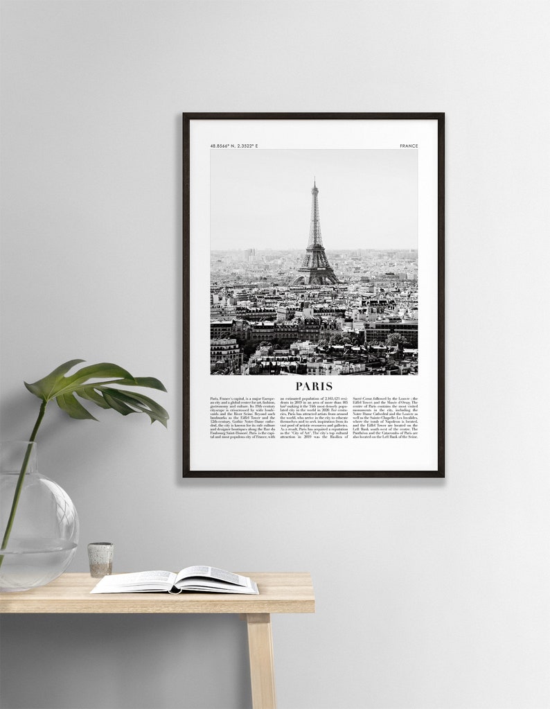 May include: A black and white photograph of the Eiffel Tower in Paris, France. The image shows the tower from a distance, with the city of Paris in the background. The image is framed in a black frame.