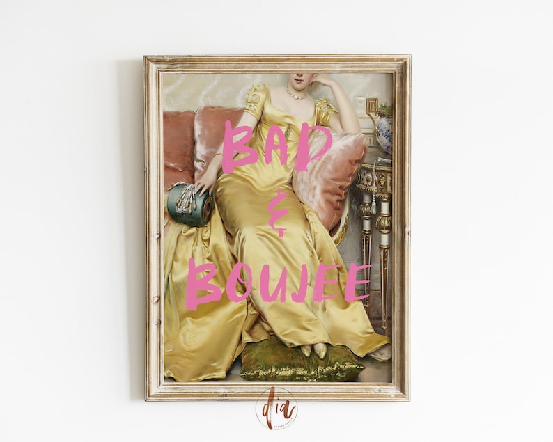 May include: A framed print of a woman in a yellow dress sitting on a couch. The text "BAD & BOUJEE" is written in pink letters over the image.