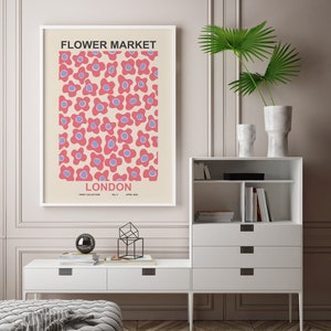 Pu&ograve; includere: Un poster incorniciato bianco con un motivo floreale rosa e blu. Il poster ha il testo "FLOWER MARKET LONDON" e "PRINT COLLECTION NO. 5 APRIL 2020".