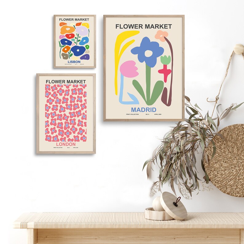 May include: Three framed prints with the title "Flower Market" and the cities Lisbon, Madrid, and London. Each print features a different abstract floral design in pink, blue, green, yellow, and red.