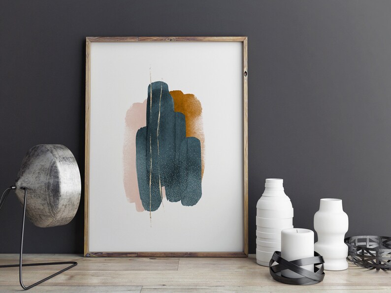 May include: Abstract art print with a teal, pink, and gold design in a wooden frame. The print is hanging on a dark gray wall.