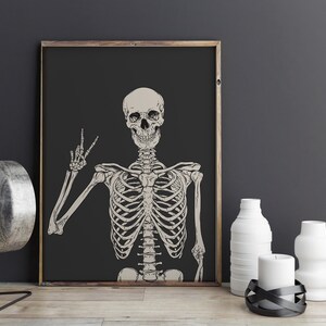 May include: A black and white illustration of a skeleton giving the peace sign. The skeleton is on a black background.