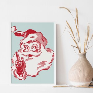 May include: A vintage-style illustration of Santa Claus with a red beard and hat, against a light blue background. He is smiling and pointing with his right index finger.