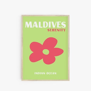 Op de afbeelding: Een groene poster met witte tekst die "MALDIVES SERENITY INDIAN OCEAN" zegt. In het midden van de poster staat een rode bloem met een groen hart.
