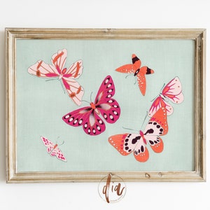 Puede incluir: Una impresi&oacute;n enmarcada que muestra varias mariposas en tonos rosa y naranja sobre un fondo azul claro. Las mariposas, de diferentes tama&ntilde;os y orientaciones, est&aacute;n enmarcadas en un marco dorado, ideal para la decoraci&oacute;n de paredes.