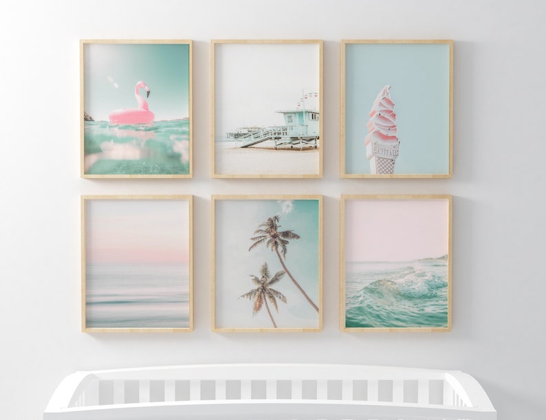 May include: Six framed prints with a beach theme. The prints feature a pink flamingo float, a beach scene with a lifeguard stand, a pink and white ice cream cone, a pink and blue sunset over the ocean, palm trees against a blue sky, and a wave crashing in the ocean.
