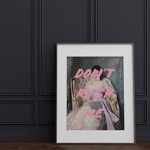 Pode incluir: Uma impress&atilde;o emoldurada de uma mulher sentada em uma cadeira com uma bolha rosa na boca. O texto "DON'T RUSH ME" est&aacute; escrito em letras rosa sobre a imagem.