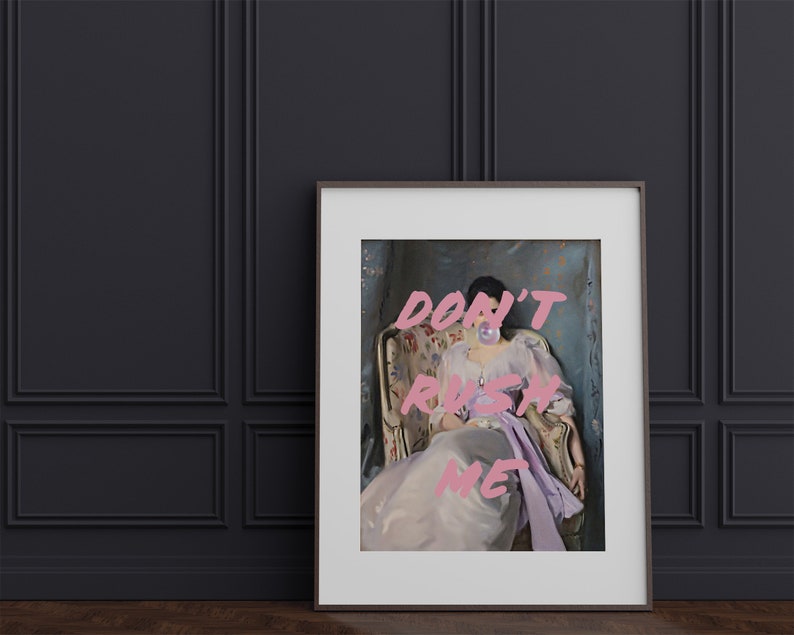 Pode incluir: Uma impress&atilde;o emoldurada de uma mulher sentada em uma cadeira com uma bolha rosa na boca. O texto "DON'T RUSH ME" est&aacute; escrito em letras rosa sobre a imagem.