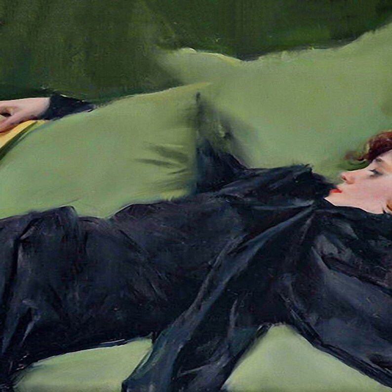 May include: A woman in a black dress lies on a green couch. She has red hair and is looking to the side. The couch is covered in a soft, green fabric.