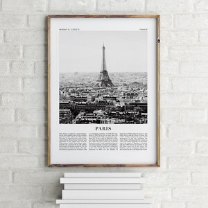 May include: A black and white photograph of the Eiffel Tower in Paris, France. The image shows the tower from a distance, with the city of Paris in the background. The image is framed in a wooden frame.