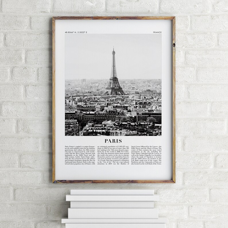 May include: A black and white photograph of the Eiffel Tower in Paris, France. The image shows the tower from a distance, with the city of Paris in the background. The image is framed in a wooden frame.
