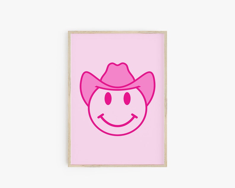 May include: Pink smiley face with a pink cowboy hat on a pink background. The smiley face is outlined in a darker pink.