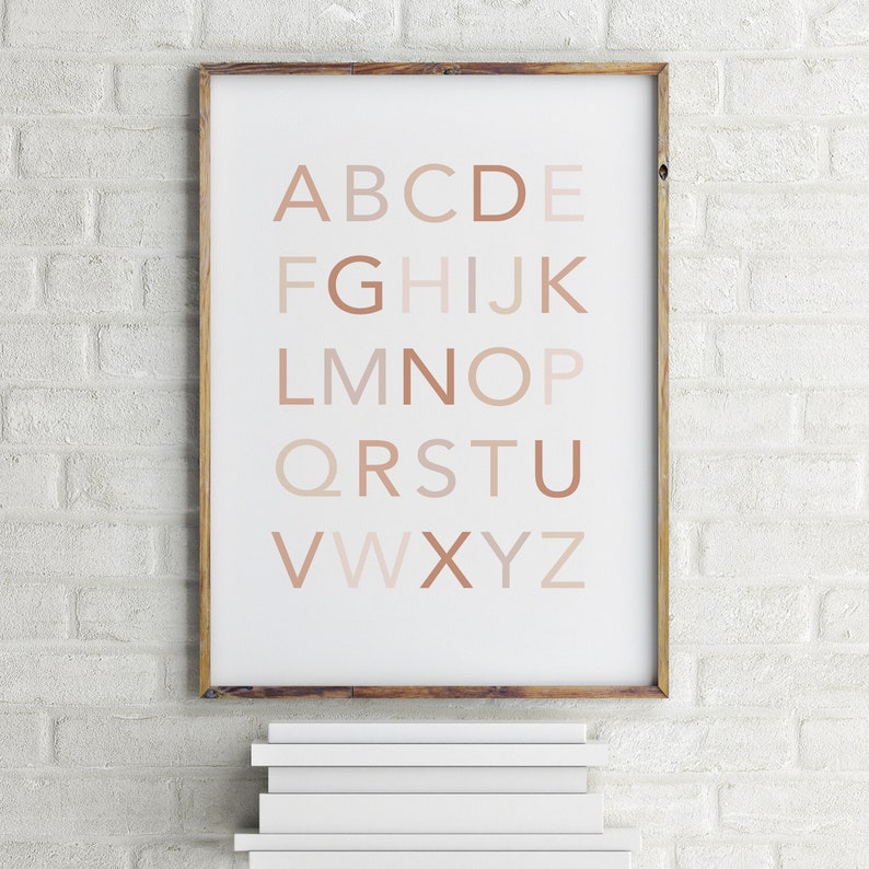 May include: A framed print of the alphabet in a neutral color palette. The letters are in a simple, sans-serif font and are arranged in rows. The letters are a gradient of brown shades, with the lightest shade at the top and the darkest shade at the bottom.