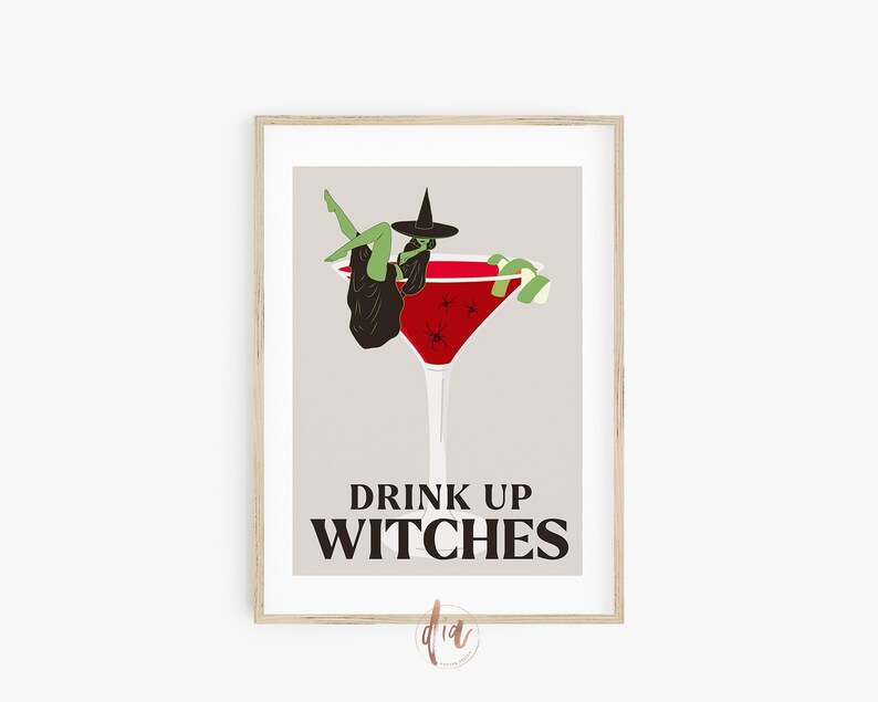 May include: A framed print with a witch sitting in a red cocktail glass with a lime garnish. The text "Drink Up Witches" is below the glass.