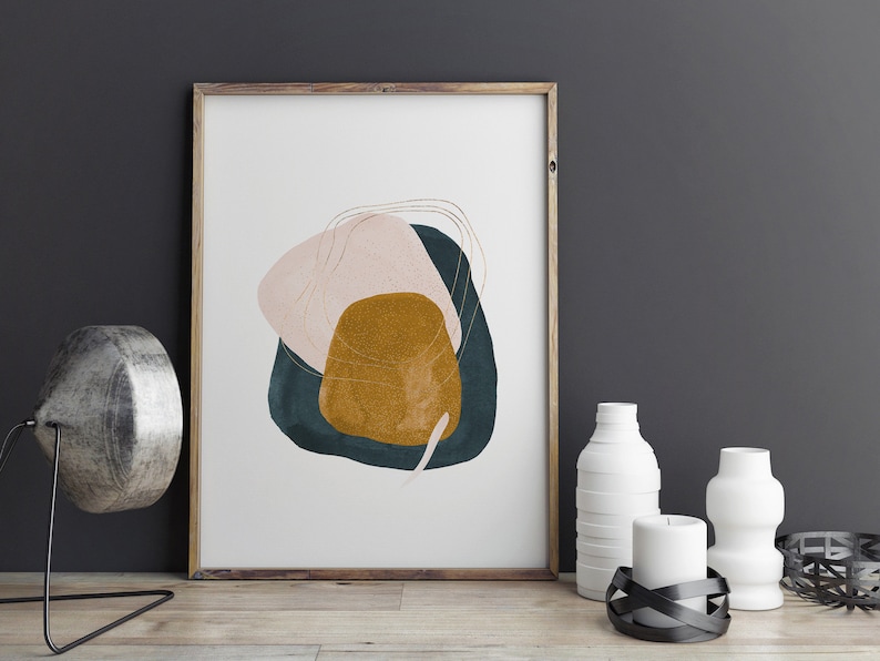 May include: Abstract art print featuring a pink, teal and gold design. The print is framed in a light wood frame.