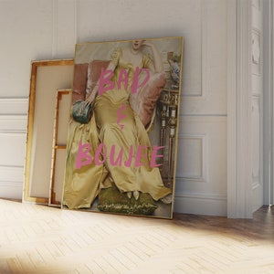 May include: A framed print of a woman in a yellow dress sitting on a couch. The text "BAD & BOUJEE" is written in pink on the print.