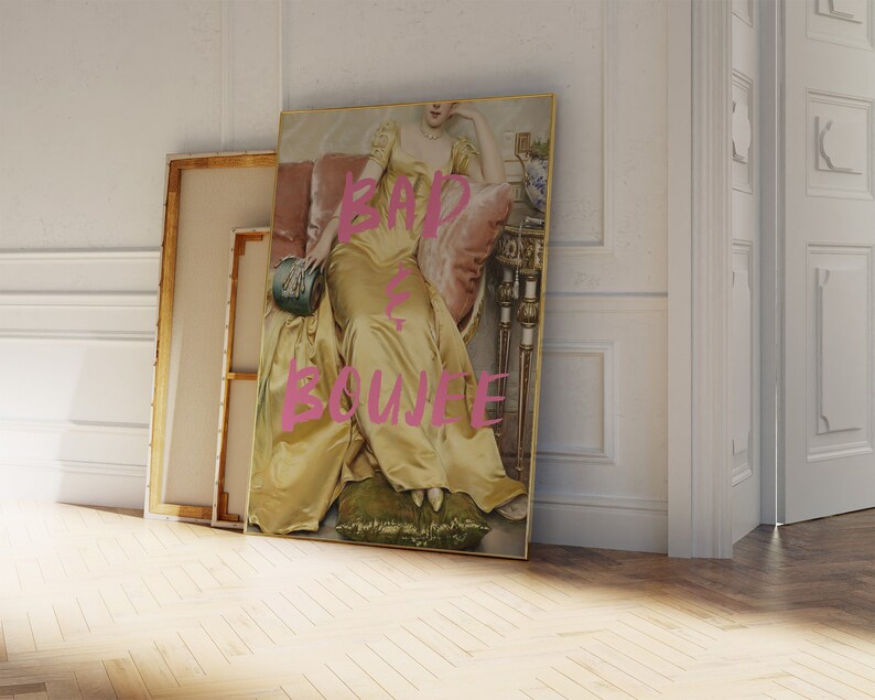 May include: A framed print of a woman in a yellow dress sitting on a couch. The text "BAD & BOUJEE" is written in pink on the print.