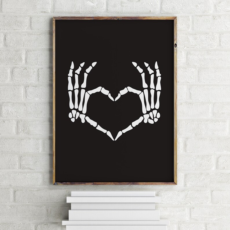 May include: A black and white printable art print featuring a pair of skeleton hands forming a heart shape.
