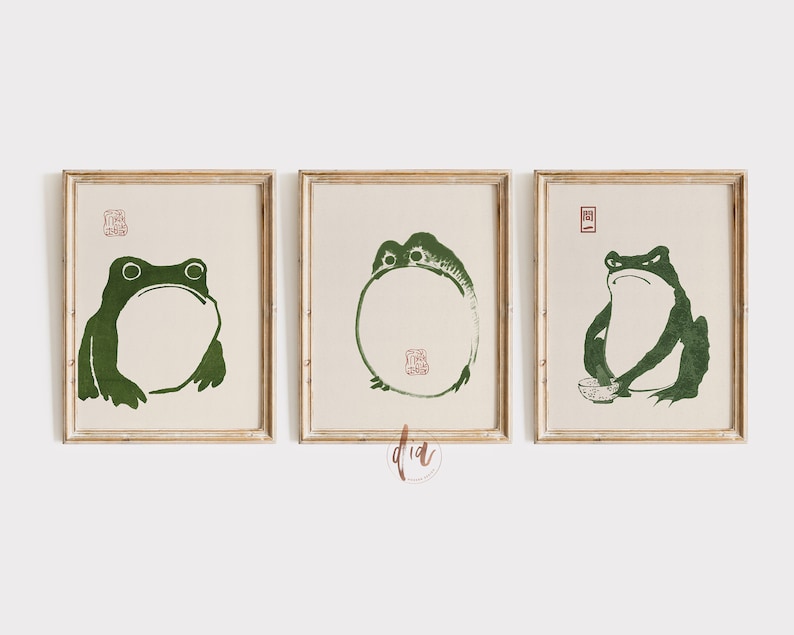 May include: Three framed prints of green frogs in different poses. The frogs are stylized and have a simple, minimalist design. The prints are set against a white background.