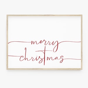 Op de afbeelding: Een ingelijst afdruk met de tekst "merry christmas" in een cursief lettertype in rood op een witte achtergrond.