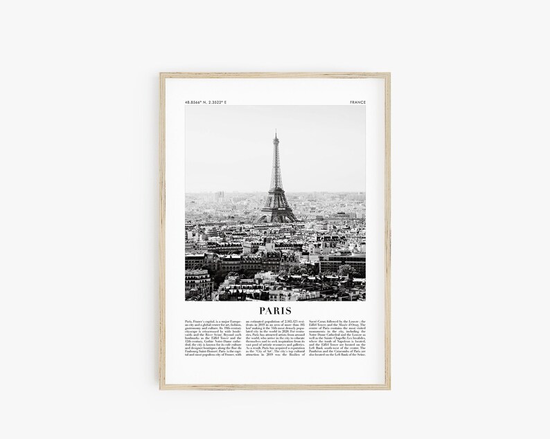May include: A black and white photograph of the Eiffel Tower in Paris, France. The image shows the tower from a distance, with the city of Paris in the background. The image is framed in a light wood frame.