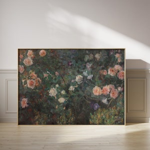 May include: A framed floral print featuring a lush garden scene. The artwork showcases a variety of roses in shades of pink and white, set against a backdrop of green foliage. The frame is a warm gold color, adding to the classic aesthetic.