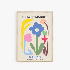 May include: A poster with the text "FLOWER MARKET MADRID" in black lettering. The poster features a colorful abstract illustration of flowers in shades of pink, yellow, blue, green, and red.