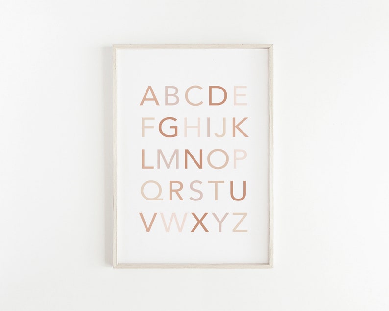 May include: A framed print with the alphabet in a neutral color palette. The letters are in a gradient of beige, brown, and pink.