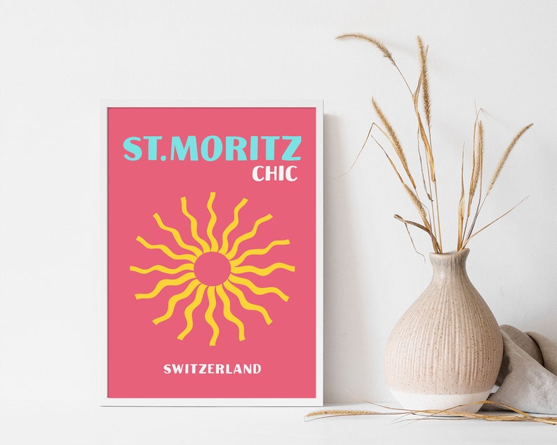 May include: A pink and white framed poster with the text "ST. MORITZ CHIC SWITZERLAND" and a yellow sun graphic.