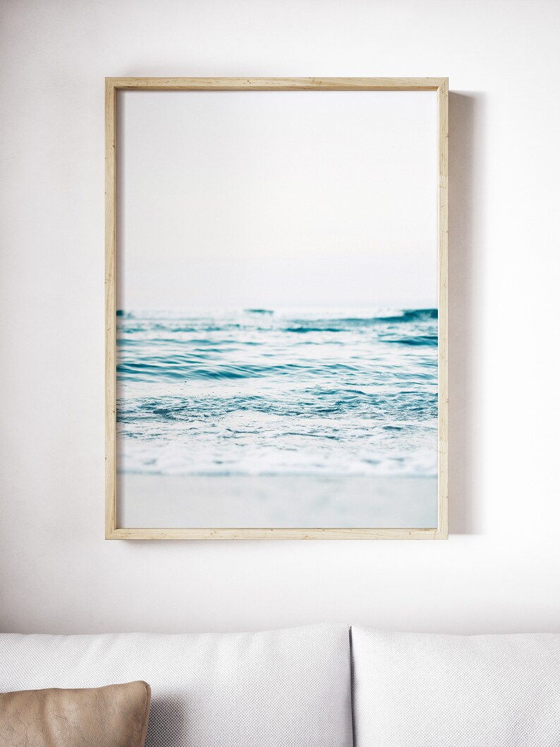 Peut inclure: Une photographie encadr&eacute;e d'un oc&eacute;an bleu avec des vagues blanches mousseuses qui se brisent sur le rivage.