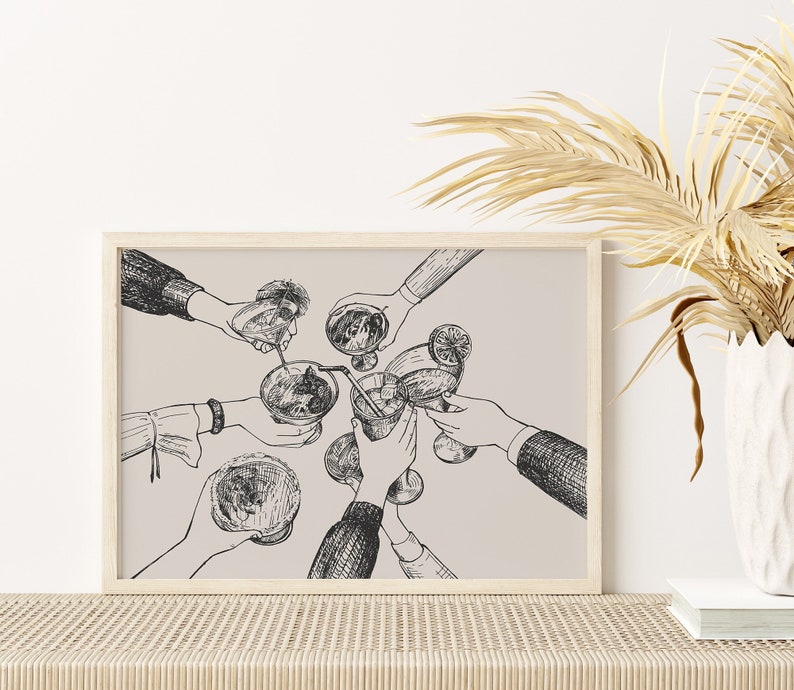 Puede incluir: Una ilustraci&oacute;n en blanco y negro de amigos brindando con c&oacute;cteles. La ilustraci&oacute;n est&aacute; impresa sobre un fondo beige claro y enmarcada en un marco de madera claro.