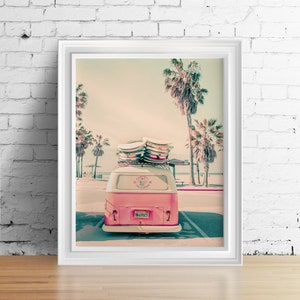 May include: A pink vintage van with surfboards on the roof parked in front of palm trees. The van has a sticker that says "Karni Surf California" and a license plate that says "TM 695CT".