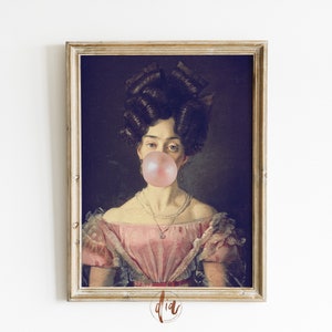 Puede incluir: Un retrato enmarcado de una mujer con un gran chicle rosa en la boca. Lleva un vestido rosa con ribete de encaje y un collar de perlas. El retrato está en un marco dorado.